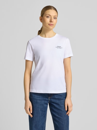 Frauenmodel trägt T-Shirt mit Label-Print und Rundhalsausschnitt von Gant, Damen T-Shirt aus Reine Baumwolle, Regular-Fit, Weiß, Rückenlänge bei Größe S: 57 cm, Ganzkörperansicht von vorne.