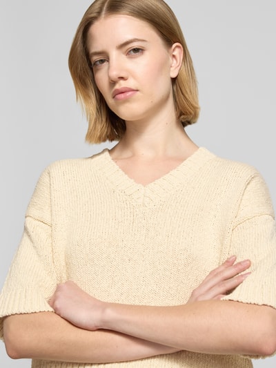 Frauenmodel trägt Regular Fit Pullover in Strick-Optik Modell 'Hannalie' von MSCH Copenhagen aus Reine Baumwolle, Halbarm, V-Ausschnitt, Nahaufnahme Oberkörper.