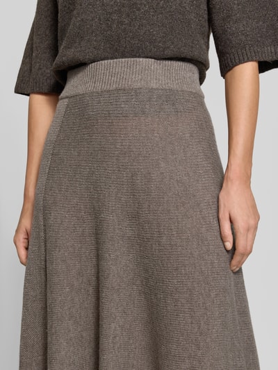 Frauenmodel trägt Wollrock mit Kaschmir-Anteil von Emporio Armani in Braun, A-Linie, elastischer Bund, Nahaufnahme Oberkörper.