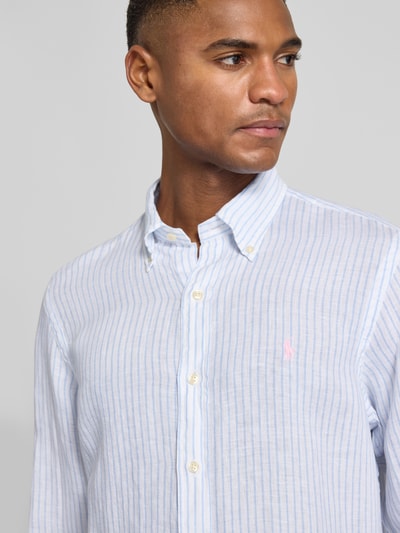 Männermodel trägt Regular Fit Freizeithemd aus reinem Leinen von Polo Ralph Lauren, blau-weiß gestreift mit Logo, Nahaufnahme Oberkörper.