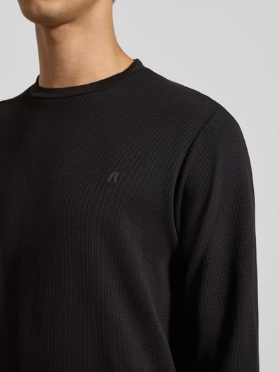 Männermodel trägt Sweatshirt mit Stehkragen von Replay in Schwarz, Waffel-Design, Label-Detail, Reine Baumwolle, Nahaufnahme Oberkörper.