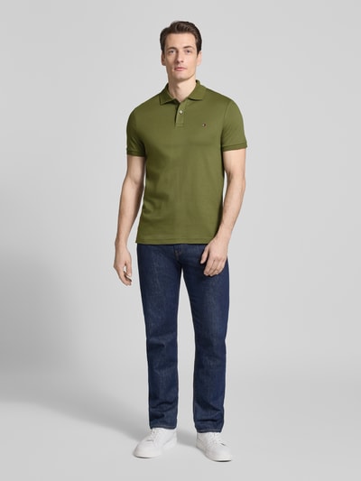 Mannelijk model draagt Regular Fit Poloshirt uit puur katoen Model 'LIQUID COTTON' van Tommy Hilfiger, melangelook, gestikt logo, polokraag, korte mouw, geribde mouwboord, rompzoom met zijsplitten, ganzenshot van voren.