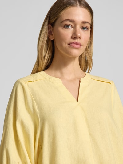 Frauenmodel trägt Bluse aus Leinen-Mix mit verlängertem Rücken Modell 'Lava' von FREE/QUENT in hellem Gelb, Loose Fit, Nahaufnahme Oberkörper. Leichter Stoff mit Tunikakragen und 3/4-Arm, optimale Länge und lockere Textur.