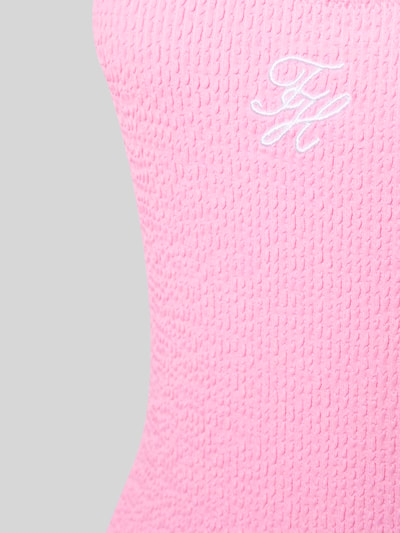 Frauenmodel trägt Badeanzug mit Logo-Stitching von TOMMY HILFIGER in Optik: Unifarben, Materialverarbeitung: Crinkle, Nahaufnahme Oberkörper.