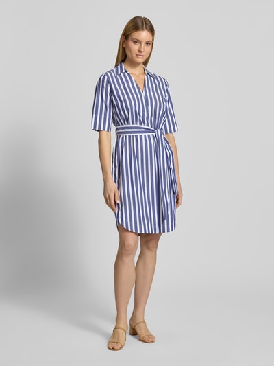 Modelka kobieca nosi sukienkę koszulową 'Knielanges Hemdblusenkleid mit Bindegürtel' z bawełny od WHITE LABEL, prosty krój, długość do kolan, kołnierzyk koszulowy, dekolt w serek, wiązany pasek, długość tyłu w rozmiarze 36: 102 cm, szerokość w rozmiarze 36: 53 cm, długość rękawów w rozmiarze 36: 33 cm, białe i niebieskie pionowe paski, gładka faktura, widok całej sylwetki z przodu.