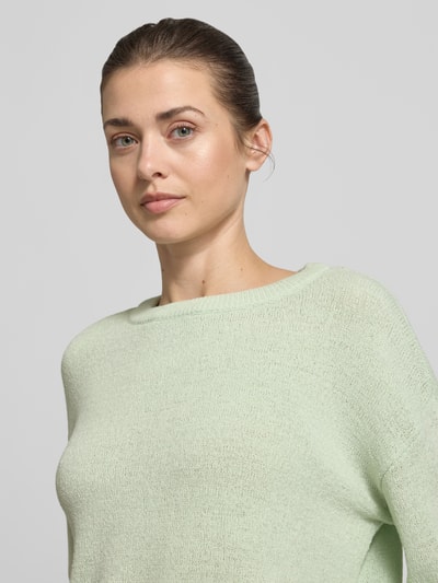 Vrouwenmodel draagt Relaxed Fit Strickpullover mit U-Boot-Ausschnitt van Tom Tailor Denim in effen lichtgroen fijngebreid materiaal, langem mouw, rolzoom aan mouw en zoom, detailopname bovenlichaam.