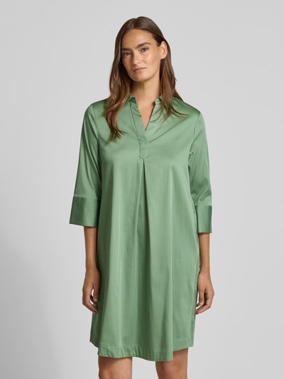 Frauenmodel trägt A-Linie Freizeitkleid aus Baumwoll-Mix von s.Oliver BLACK LABEL in sanftem Grün, glatte Struktur, Ganzkörperansicht von vorne.