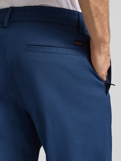Männermodel trägt Tapered Chino mit Kordelzug Modell 'CHINO ST-P' von BOSS Orange, Unifarben, Baumwoll-Mix, Detailaufnahme Rückansicht.