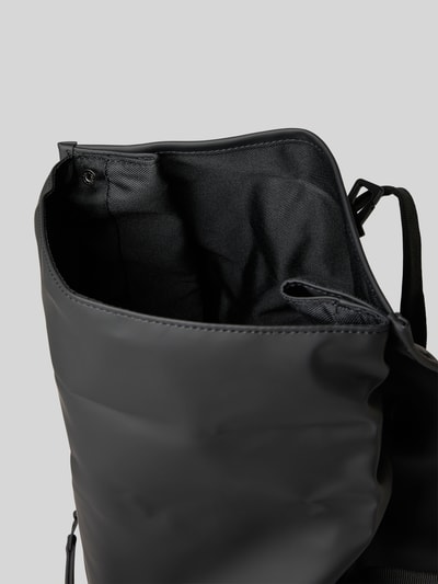 Produktfoto, Rolltop Rucksack mit Reißverschlusstasche von Rains in Schwarz, glatte Oberfläche, verstellbare Träger, 31 cm Breite, 61 cm Länge, 15 cm Tiefe, Karabinerhaken, Tragehenkel, 74 cm Schulterriemen.