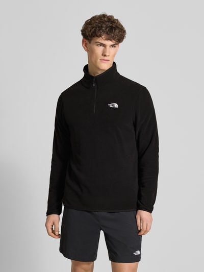 Mannenmodel draagt Fleecepullover met Troyer-Kragen Modell 'GLACIER' van The North Face, fleece, rechte fit, label-stitching, elastische boorden, zwart, vooraanzicht hele lichaam.