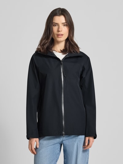 Frauenmodel trägt Regular Fit Jacke mit Logo-Print Modell 'Treeline' von PEAK PERFORMANCE in Schwarz, glatte Textur, Ganzkörperansicht von vorne, Rückenlänge 71 cm, Schulterbreite 44 cm, Brustweite 53 cm, Ärmellänge 55 cm, mit Stehkragen und Kapuze.