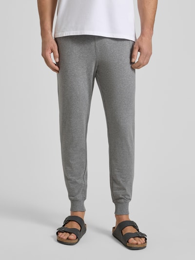 Männermodel trägt Sweatpants mit elastischem Bund und Tunnelzug von JOOP! Collection, grauer Baumwoll-Mix mit Stretch-Anteil, Regular-Fit, Nahaufnahme Unterkörper von vorne.