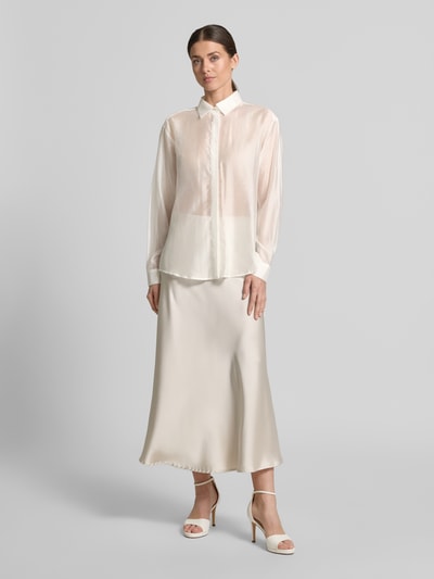 Frauenmodel trägt Regular Fit Bluse aus Lyocell-Mix in semitransparentem Design von Jake*s Cocktail, leicht glänzende Struktur in Creme, Hemdblusenkragen, verdeckte Knopfleiste, ganzkörperansicht von vorne.