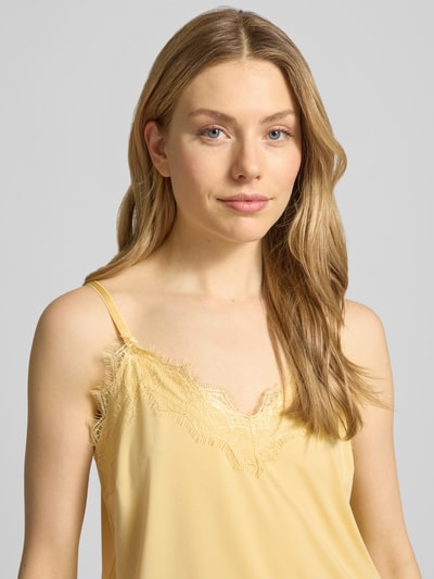 Frauenmodel trägt Regular Fit Top mit Spitzenbesatz Modell 'Bicco' von FREE/QUENT in Gelb, V-Ausschnitt, Nahaufnahme Oberkörper.