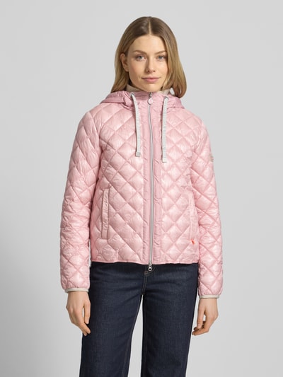Frauenmodel trägt Regular Fit Jacke in Stepp-Optik Modell 'YOSIE' von Frieda & Freddies in Rosa mit Kapuze, Eingrifftaschen, Ganzkörperansicht von vorne.