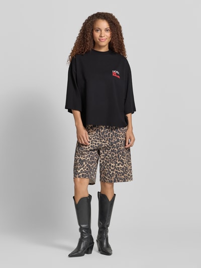 Frauenmodel trägt Cropped T-Shirt mit Statement-Print Modell 'Vacation' von Karo Kauer, Oversized-Fit, Reine Baumwolle, Gerippter Rundhalsausschnitt, schwarze Farbe, Rückenlänge bei Größe S: 62 cm, Ganzkörperansicht von vorne.