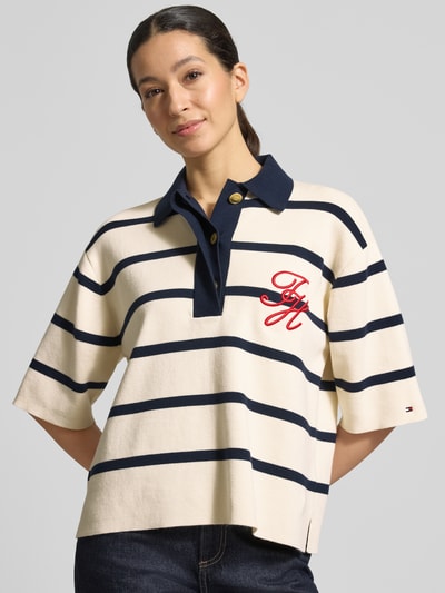 Vrouwenmodel draagt Regular Fit Poloshirt uit katoenmix van Tommy Hilfiger, all-over motief, gestikt logo, fijngebreid, Ganzkörperansicht von voren.