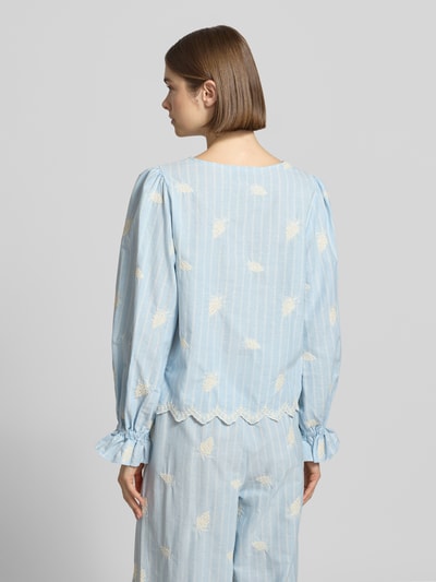 Frauenmodel trägt Bluse mit Schnürung Modell 'Ninon' von OH APRIL aus Reine Baumwolle mit Rüschenärmel, Label-Stitching, Straight Fit, Rückenlänge 54 cm, Ärmellänge 61 cm, Ganzkörperansicht Rückansicht.