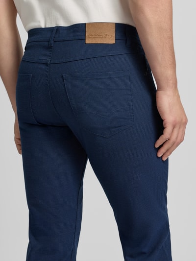 Männermodel trägt Chino mit 5-Pocket-Design von Christian Berg Men in Dunkelblau, Material-Mix, gerader Schnitt, Ganzkörperansicht Rückansicht.