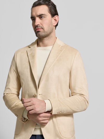Mężczyzna nosi Regular Fit Sakko mit Reverskragen Modell 'Benito' von CINQUE w beżowym kolorze, elastyczny materiał, ganzkörperansicht z przodu. Krój regular fit, długość pleców w rozmiarze 50: 73 cm, szerokość ramion w rozmiarze 50: 45 cm, długość rękawa w rozmiarze 50: 65 cm.
