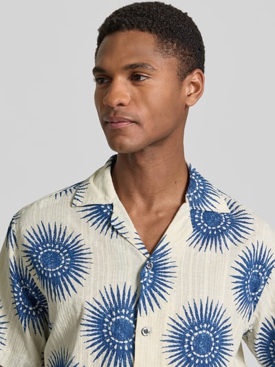 Männermodel trägt Regular Fit Freizeithemd im Allover-Look Modell 'BILBAO' von Jack & Jones Premium, creme mit blauen Mustern, Reverskragen, reine Baumwolle, Nahaufnahme Oberkörper.