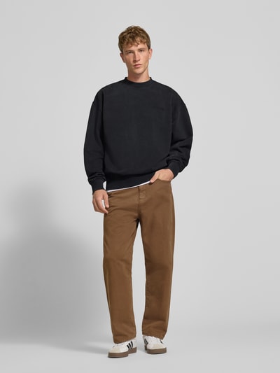 Männermodel trägt Relaxed Fit Sweatshirt aus Baumwoll-Mix von PEGADOR, schwarze Farbe, Logo-Stickerei, Ganzkörperansicht von vorne.