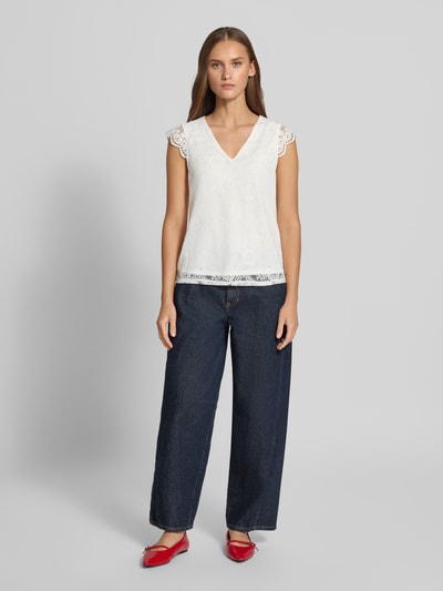Vrouwenmodel draagt Regular fit blusentop met kant model 'OLLINE' van PIECES, Dames blusentop, wit met fijne textuur, donkerblauwe broek, Ganzkörperansicht van voren.