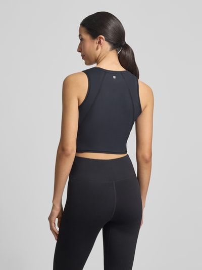 Frauenmodel trägt Cropped Tanktop mit Logo von Salomon aus Material-Mix mit Stretch-Anteil, Schwarz, Rückenlänge 35 cm, Ganzkörperansicht Rückansicht.