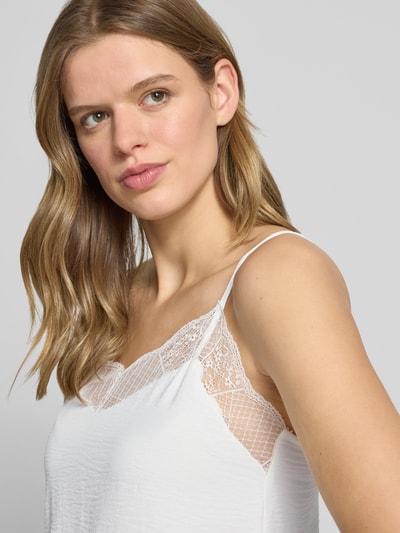 Frauenmodel trägt Relaxed Fit Blusentop mit Spitzenbesatz Modell 'TIFFANY' von Pieces, Optik: Unifarben, Passform: Relaxed-Fit, V-Ausschnitt, Applikation: Spitzenbesatz, Trägerform: Spaghettiträger, Materialverarbeitung: Crêpe, Nahaufnahme Oberkörper.