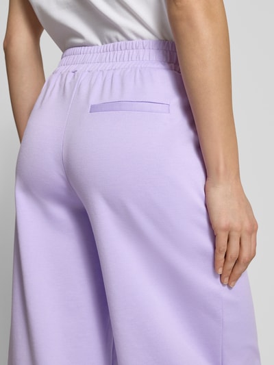 Vrouwenmodel draagt Wide Fit broek met elastische band model 'Kate' van ICHI, materiaalmix met viscose, binnenbeenlengte maat S 66 cm, bandwijdte maat S 37 cm, lila kleur, detailopname rugaanzicht.