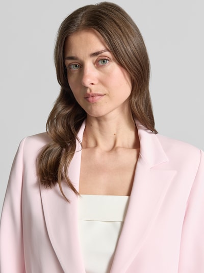 Frauenmodel trägt Blazer mit Reverskragen Modell 'REWI' von Rinascimento in hellrosa, Material-Mix, Nahaufnahme Oberkörper.