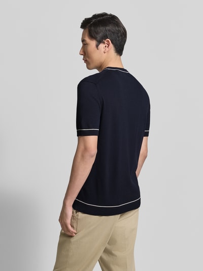 Männermodel trägt Strickshirt mit Rundhalsausschnitt von Gant in Dunkelblau mit beigen Details, Baumwoll-Modal-Mix, Ganzkörperansicht Rückansicht.