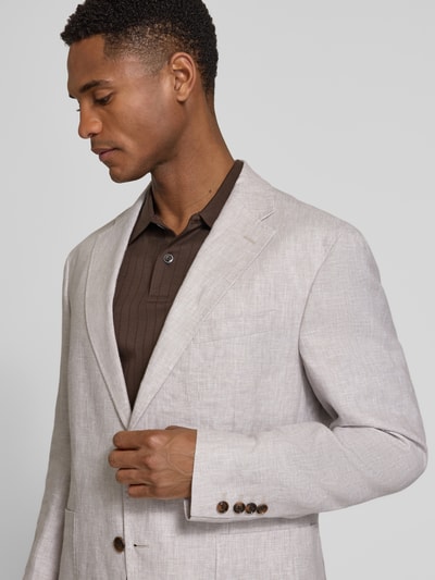 Männermodel trägt Slim Fit 2-Knopf-Sakko aus Leinen Modell 'Hoverest' von JOOP! Collection in Beige, Nahaufnahme Oberkörper. Sakko mit Reverskragen und aufgesetzten Taschen.
