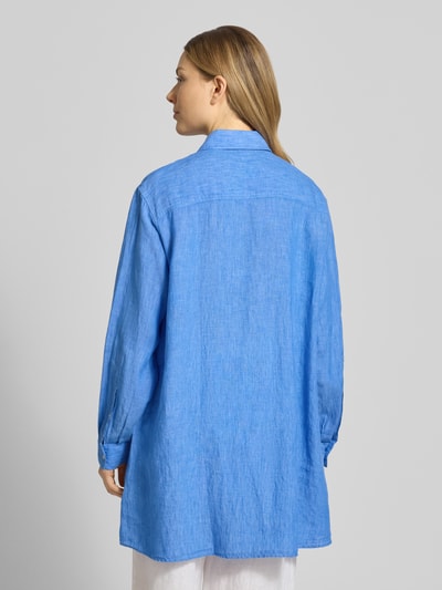 Frauenmodel trägt Relaxed Fit Longbluse aus Leinen Modell 'TAHIA' von 0039 Italy in Blau mit Hemdblusenkragen, Knopfleiste, Brusttasche, Rückenlänge 86 cm, Ärmellänge 58 cm, Ganzkörperansicht Rückansicht.