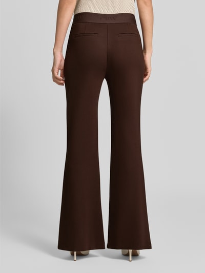 Frauenmodel trägt Flared Cut Hose aus Viskose-Mix mit Gesäßtaschen von Christian Berg Woman, dunkelbraun, glatte Oberfläche, Ganzkörperansicht Rückansicht.