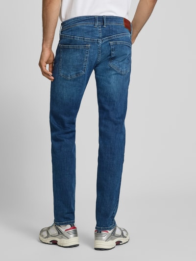 Männermodel trägt Slim Fit Jeans aus Baumwoll-Mix Modell 'Hatch' von Pepe Jeans in Blau, mittlere Waschung, Ganzkörperansicht Rückansicht. Herren Slim Fit Jeans von Pepe Jeans.