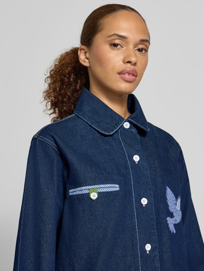 Frauenmodel trägt Jacke aus reiner Baumwolle in Denim-Optik Modell 'Edda' von LOLLYS LAUNDRY, dunkles Blau, Zierstickerei, Nahaufnahme Oberkörper.