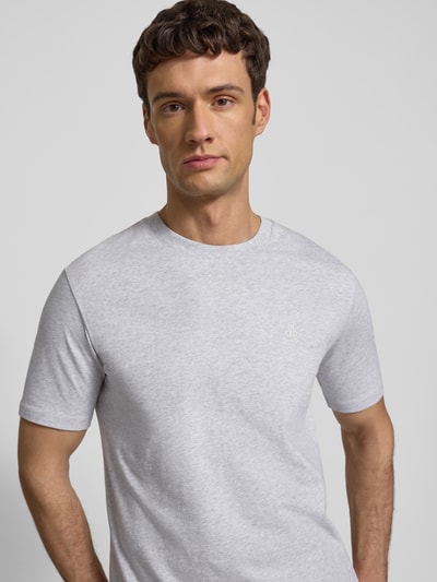 Männermodel trägt T-Shirt mit Label-Print von MARC O'POLO in Unifarbenes-Design, Reine Baumwolle, gerader Schnitt, Nahaufnahme Oberkörper.
