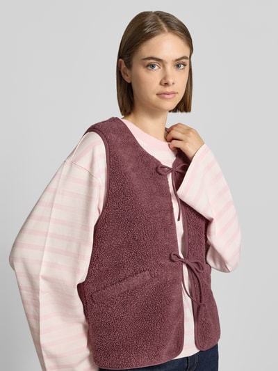 Frauenmodel trägt Regular Fit Weste mit Schnürung Modell 'BABY' von ONLY, weinrot, flauschige Textur, Ganzkörperansicht von vorne, Damen Weste von ONLY.