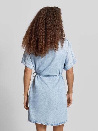 Modelka prezentuje Relaxed Fit Jeanskleid aus reiner Baumwolle von Marc O'Polo Denim w tkaninie stylizowanej na denim, mini, kołnierzyk koszulowy, wiązany pasek, listwa guzikowa, krótki rękaw, materiał: czysta bawełna. Widok całej sylwetki od tyłu.