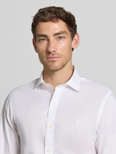 Männermodel trägt Slim Fit Businesshemd aus reiner Baumwolle von Polo Ralph Lauren in Weiß, feine Textur, Nahaufnahme Oberkörper.