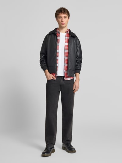 Männermodel trägt T-Shirt aus Baumwolle von Alpha Industries, Herren T-Shirt in Reine Baumwolle, Gerader-Schnitt, Rundhalsausschnitt, Label-Details, Rückenlänge 68 cm bei Größe M, Ganzkörperansicht von vorne.