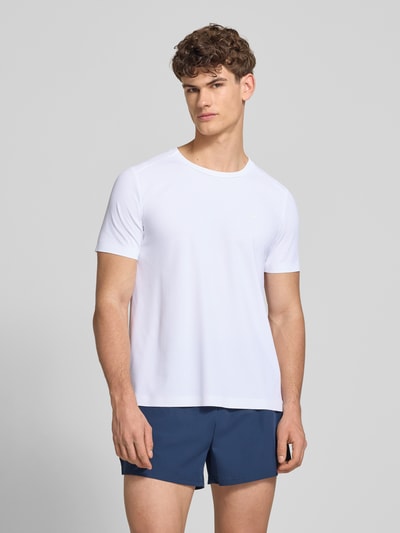 Mężczyznę model nosi T-Shirt mit Strukturmuster Modell 'TELLER TEE' von Ellesse, biały kolor, krój regular fit, logo, materiał z domieszką stretchu, okrągły dekolt, długość tyłu w rozmiarze M: 67 cm, widok z przodu, ujęcie całopostaciowe.