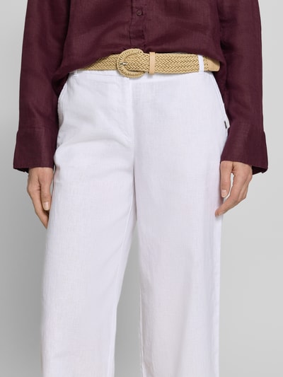 Frauenmodel trägt Culotte aus Leinen-Mix mit Gürtel von Christian Berg Woman in Weiß, weiter Schnitt, französische Taschen, Nahaufnahme Oberkörper.