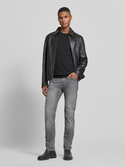 Männermodel trägt Regular Fit Jeans aus Baumwoll-Mix Modell 'Arne Pipe' von MAC in Grau mit 5-Pocket-Design, Ganzkörperansicht von vorne.