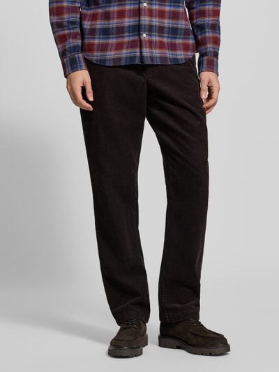 Männermodel trägt Straight Fit Cordhose aus reiner Baumwolle Modell 'DOVER' von Tommy Hilfiger in Dunkelbraun, Nahaufnahme Unterkörper. Herren Cordhose von Tommy Hilfiger