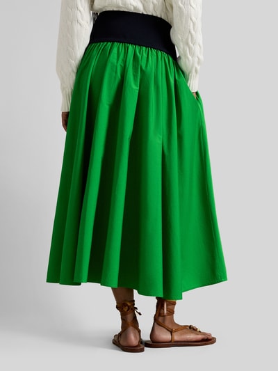 Vrouwenmodel draagt 'Ausgestellter Midi-Rock aus reiner Baumwolle' van Polo Ralph Lauren in two tone groen, uitlopend model, midi-lengte, logo-stiksel, zonder sluiting, gemaakt van pure katoen. Volledige achteraanzicht.