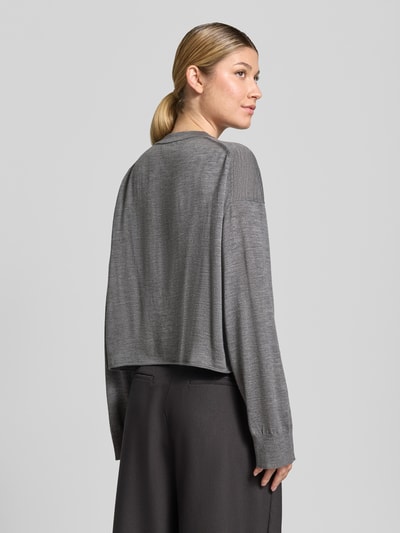 Frauenmodel trägt Strickpullover aus Schurwolle Modell 'MALESE' von DRYKORN, relaxed Fit, grau, lockere Passform, Ganzkörperansicht Rückansicht.