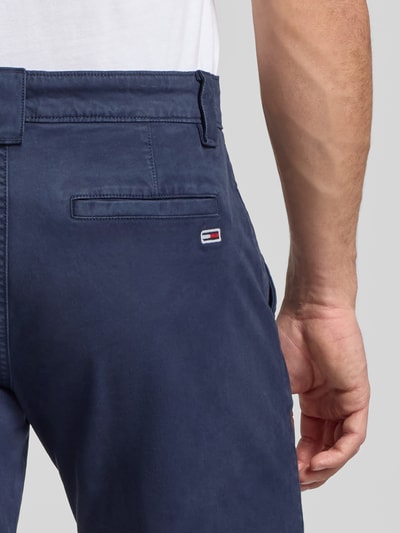 Männermodel trägt Regular Fit Chino aus Baumwoll-Mix Modell 'SCANTON' von Tommy Jeans, Optik: Unifarben, Detailaufnahme Rückansicht.