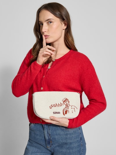 Frauenmodel trägt Shoulder Bag mit Ziersteinbesatz Modell 'Timmy' von Staud, cremefarben, Oversize-Grafik, Jeans, rote Strickjacke, Nahaufnahme Oberkörper. Damen Shoulder Bag mit Überschlag, abnehmbarem Schulterriemen, Maße ca. 27x15x6 cm, Riemenlänge ca. 57 cm.